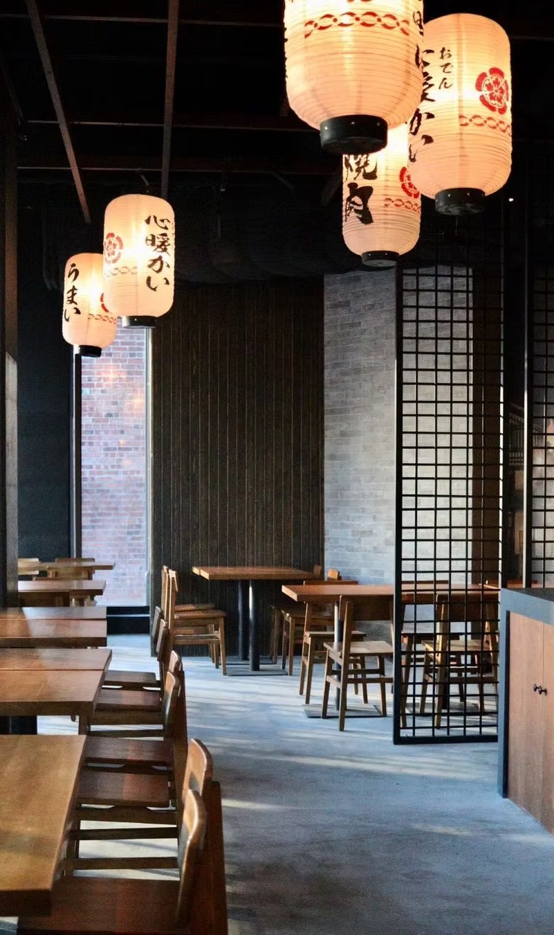 Dining room with hanging lanterns, shoji screens and wooden tables