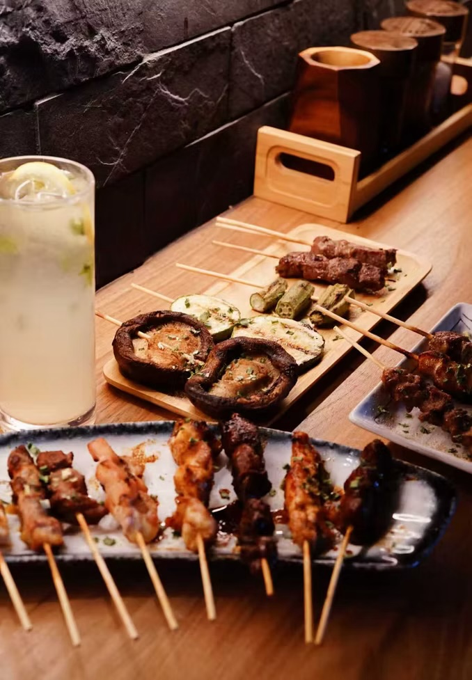 Platter of assorted skewers with grilled mushrooms and a yuzu highball